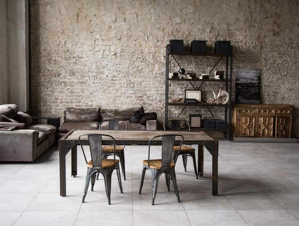 This is an industrial home décor with table, brick wall, tall ceilings and storage.