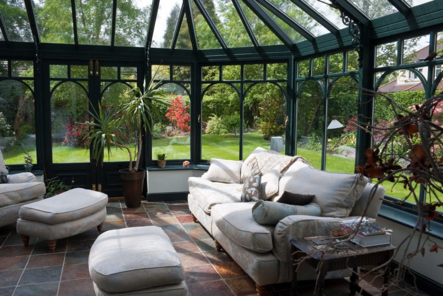 Large all-glass sunroom with sofa and other lounge furniture