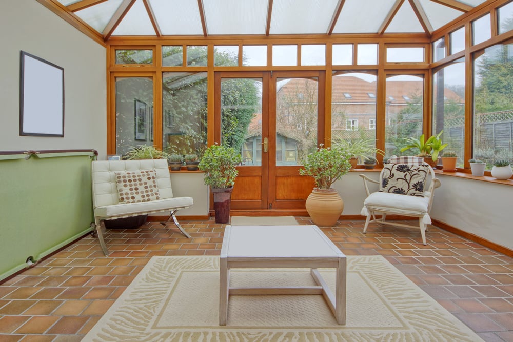 A country-style, tiled sunroom dominated with warm tones of brown and orange.
